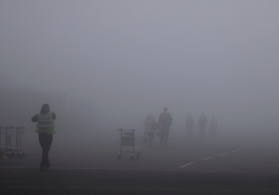 People walk amidst heavy fog at the Indira Gandhi International Airport in New Delhi, India. (REUTERS/ Anushree Fadnavis)