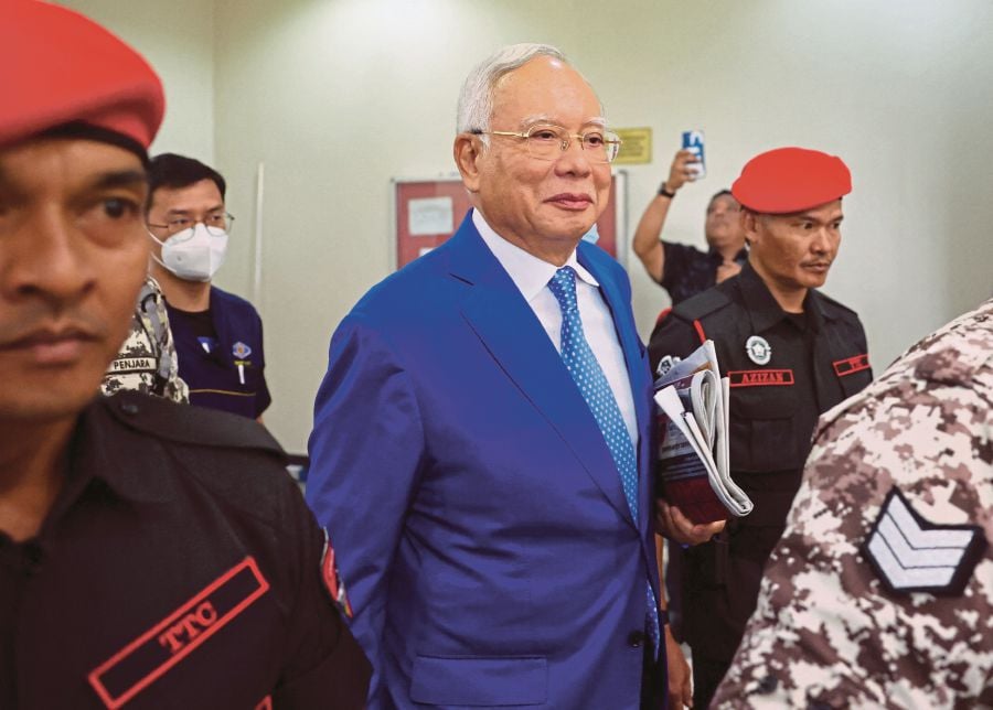 Former Malaysian Prime Minister Najib Razak escorted by prison officers as the jailed politician left the court after court proceedings in Kuala Lumpur. (REUTERS file pic/Hasnoor Hussain)