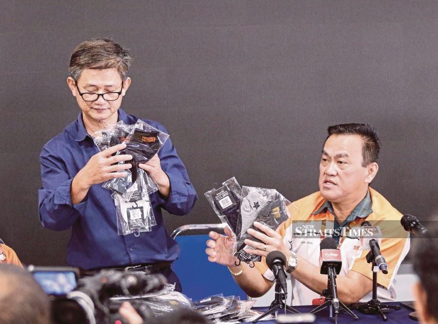 Xin Jian Chang Sdn Bhd owner Soh Chin Huat (left) and KK Super Mart and Superstore Sdn Bhd, Datuk Seri Dr KK Chai showing some of the offendin socks. NSTP file pic