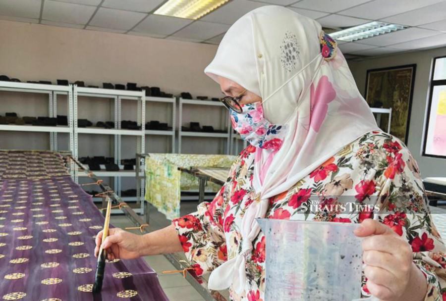 Raja Permaisuri Agong Tunku Azizah Aminah Maimunah Iskandariah adding another layer of colour to her hand-blocked batik. -NSTP/FAUZIAH ISMAIL