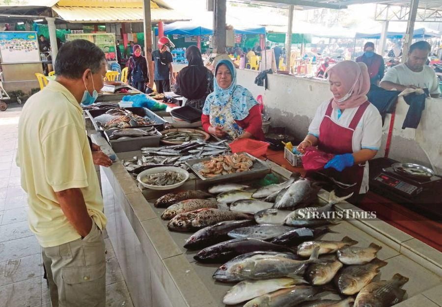 Salmiah Ramli (second from right) at her fish stall at the Kuala Kedah fishermen’s market in Alor Star.  PIC BY AHMAD MUKHSEIN MUKHTAR