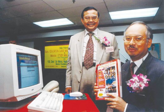 Najib with a copy of the Education Guide Malaysia (fifth edition). Looking on is Challenger Concept president Datuk Dr Yahya Ibrahim.