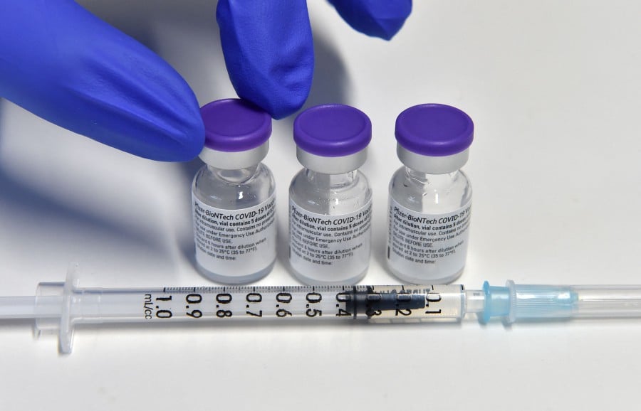 A health worker holds a vial with the Pfizer-BioNTech COVID-19 vaccine against the coronavirus at the vaccination center in Freising, southern Germany. - A booster shot of the anti-Covid-19 vaccine developed by Pfizer/BioNTech is 95.6 percent effective against symptomatic infection, according to trial data published by the makers on October 21, 2021. -AFP file pic