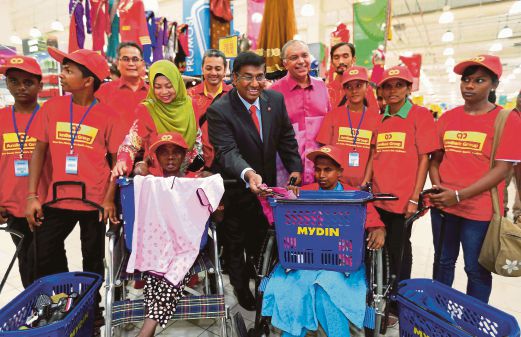  Ganesh Kumar Nadarajah (in a suit) handing out goodies to the underprivileged. Also present is Mydin Wholesale Sdn Bhd managing director Datuk Wira Ameer Ali Mydin (on Ganesh’s left). Pic by Salhani Ibrahim 