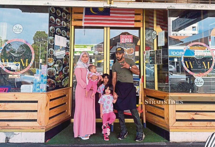 Wan Siti Hajar Wan Yaacob with her husband and children in front of their restaurant in Melbourne recently. - Pic courtesy of Wan Siti Hajar Wan Yaacob