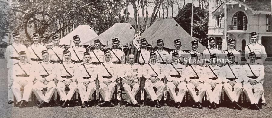 Officers from the 1st Malay Regiment battalion sitting with British High Commissioner Sir Henry Gurney after a presentation ceremony in Taiping, Perak. - Pix by Alan Teh Leam Seng