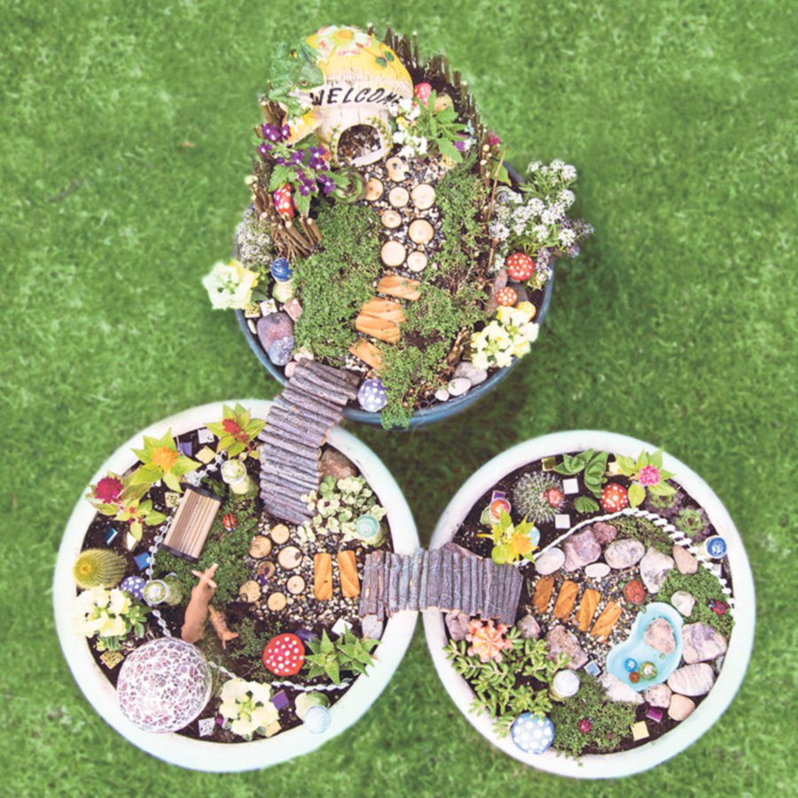 Unique fairy rock gardens in flower pots, complete with fairy house, wooden bridges and meandering fences.