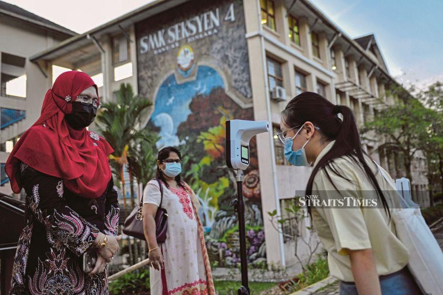 A Sijil Pelajaran Malaysia candidate having her temperature checked at SMK Seksyen 4 in Bandar Kinrara, Puchong, in February this year. PIC BY AIZUDDIN SAAD