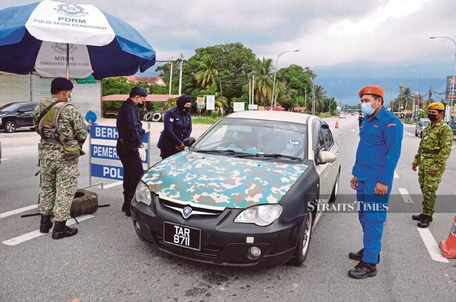 Policemen conducting checks at a roadblock in Terengganu. - Malaysia will be placed under a full lockdown for two weeks starting June 1. -- Bernama File Pix