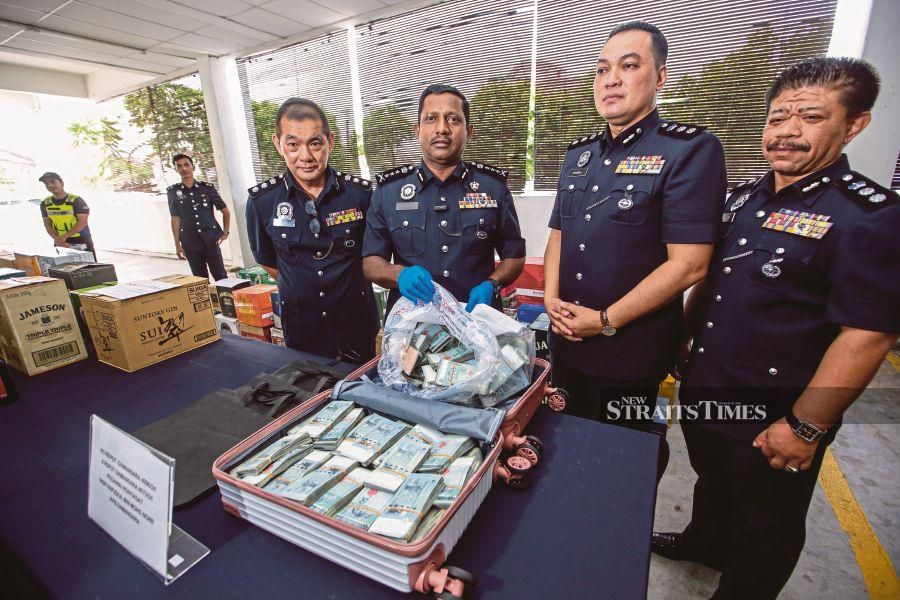 Selangor police chief Datuk Hussein Omar Khan (2nd from left) showing the luggage containing the cash. NSTP Pic