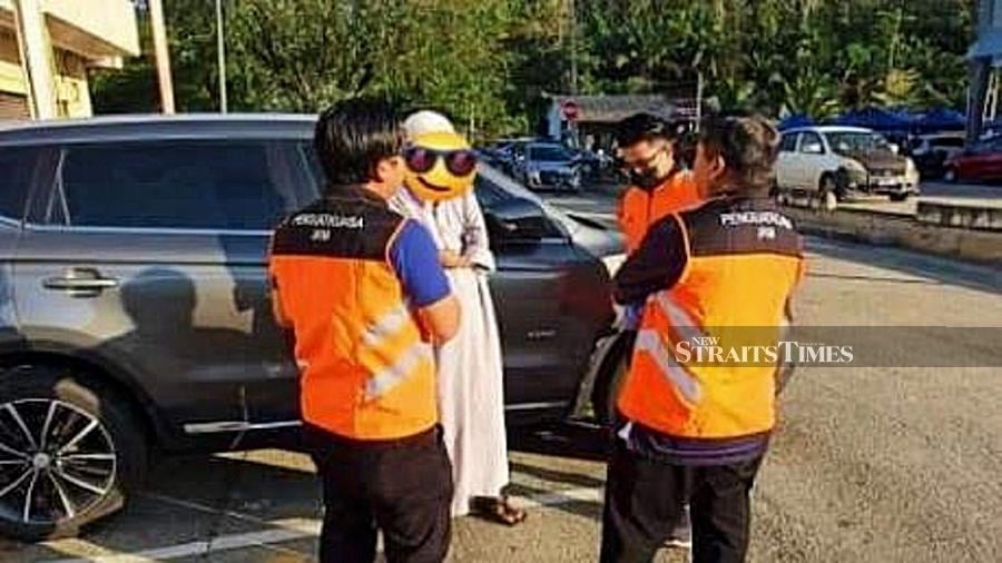 Social Welfare Department personnel speaking to the man at the Sri Jaya night market, Maran in Pahang. - Pic courtesy of the department. 