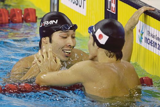 Japan’s Kosuke Hagino (left) is congratulated by compatriot Ryosuke Irie after winning the 100-metre freestyle final yesterday. AP pic