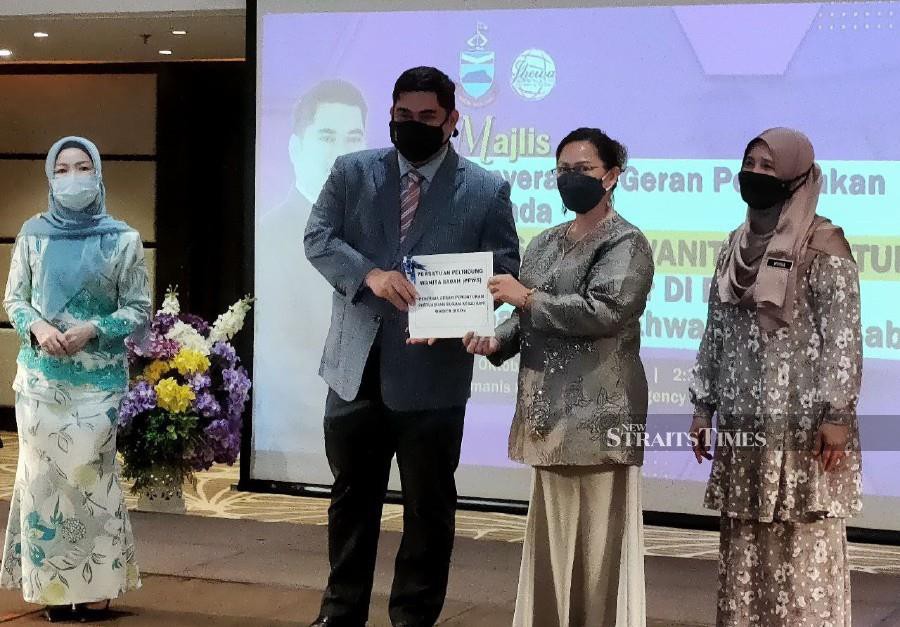 Sabah Community Development and People's Wellbeing minister Datuk Shahelmey Yahya (second left) presented grant to one of the women association at Kimanis Ballroom, Hyatt. -NSTP/IZWAN ABDULLAH