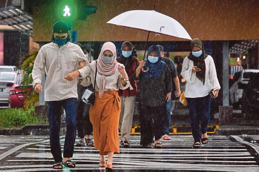 Pedestrians wearing face masks crossing the road in Dataran Pahlawan, Melaka, on Wednesday. BERNAMA PIC