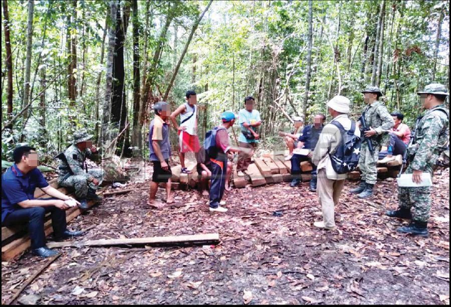 Malaysian soldiers and police, together with the five villagers, visiting the scene where the villagers were allegedly detained near Kampung Danau Melikin in Sarawak.