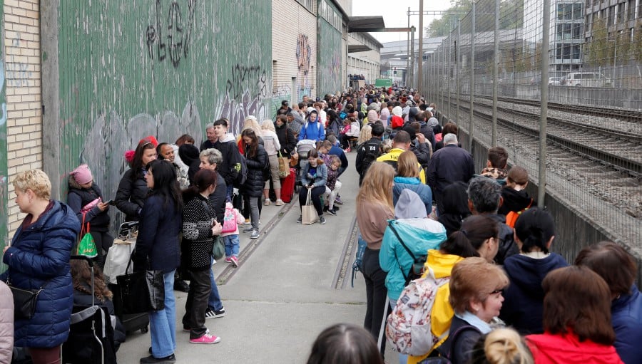 People queue for food at a distribution depot of Swiss aid organisation "Essen fuer Alle" (Food For All) in Zurich, Switzerland April 23, 2022.  -REUTERS PIC