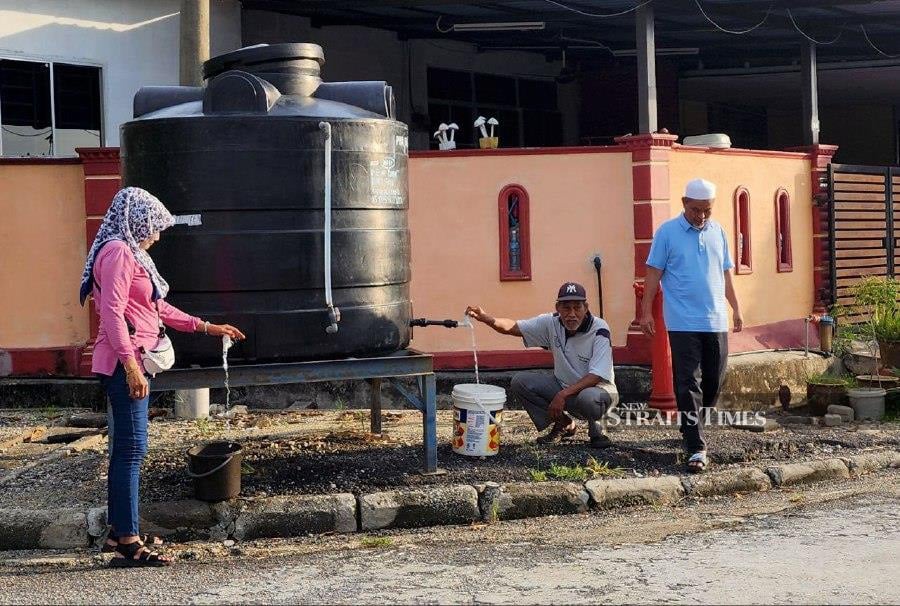 The residents of Taman Widuri fetch water outside the Taman Widuri compound, Sungai Jawi, Penang. NSTP/MIKAIL ONG