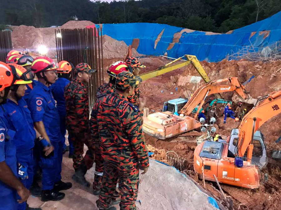 Rescuers in the midst of search and rescue process at the Tanjung Bungah landslide site. Pix courtesy of Fire and rescue department 