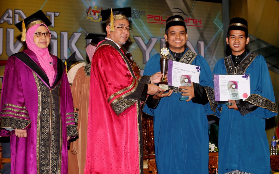 Melaka Chief Minister Adly Zahari (2nd-left) presents the award to Nur Hamdee Ramli (2nd-right) and Mohammad Khairul Jalaludin (right). Looking on is Merlimau Melaka Polytechnic (PMM) Deputy Director (Academic) Rosita Zainal (left). Pic by RASUL AZLI SAMAD