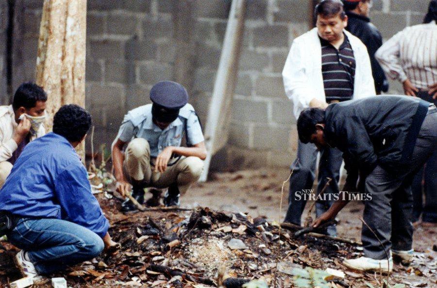  Policemen looking for evidence in the murder of Batu Talam (Pahang) state assemblyman Datuk Mazlan Idris in Kampung Lata Jarum, Hulu Dong, in Raub, Pahang, on July 22, 1993. 