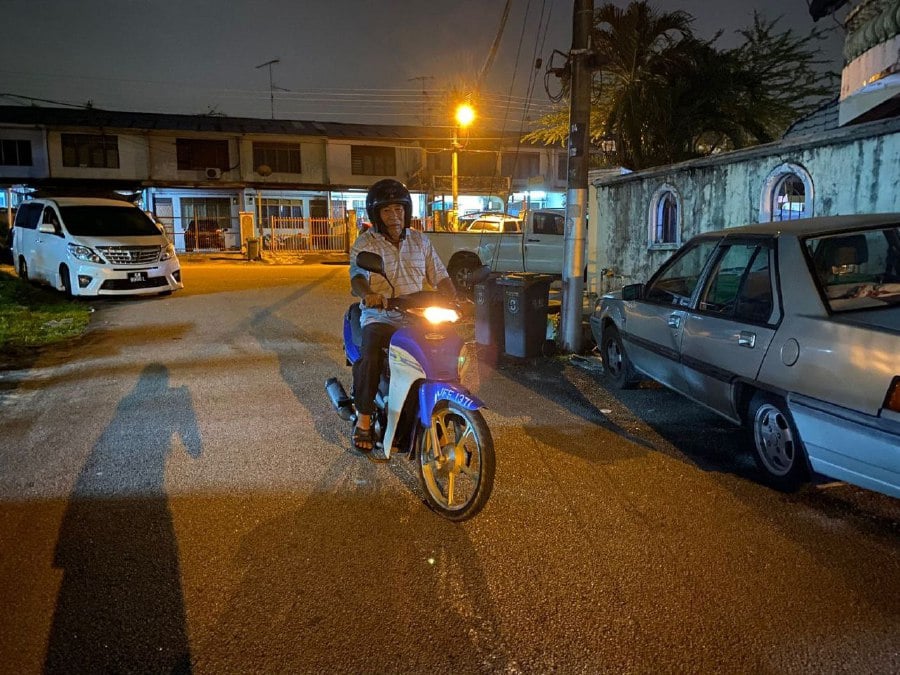 Cheong Kah Pin leaves his house at 2am, riding his motorcycle slowly so as to avoid traffic. -Pic from 8world News FB