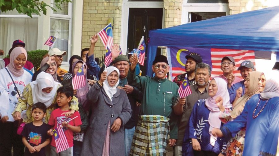 Mohamed Nor Hamid (in green) and fellow Malaysians waving the Jalur Gemilang in front of the Jermyn Street house to mark the National Day in 2022.