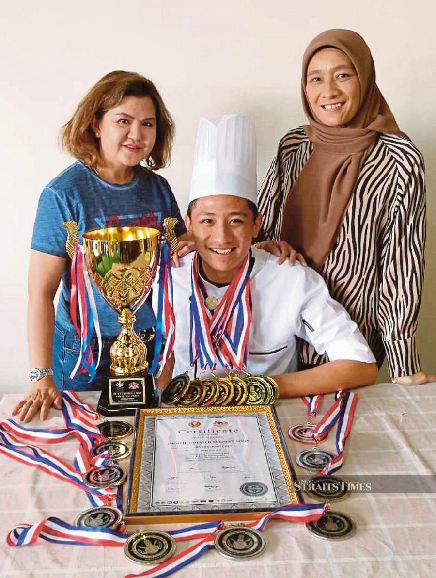 Young chef Danish Adham Nuqman Soon (centre) with the medals and trophy he won at the 2019 World Chef Championship recently. With him are his mum, Nurliza Adnan (right), and Datuk Michelle Soon Cheng Luan.NSTP/IZZALI ISMAIL 