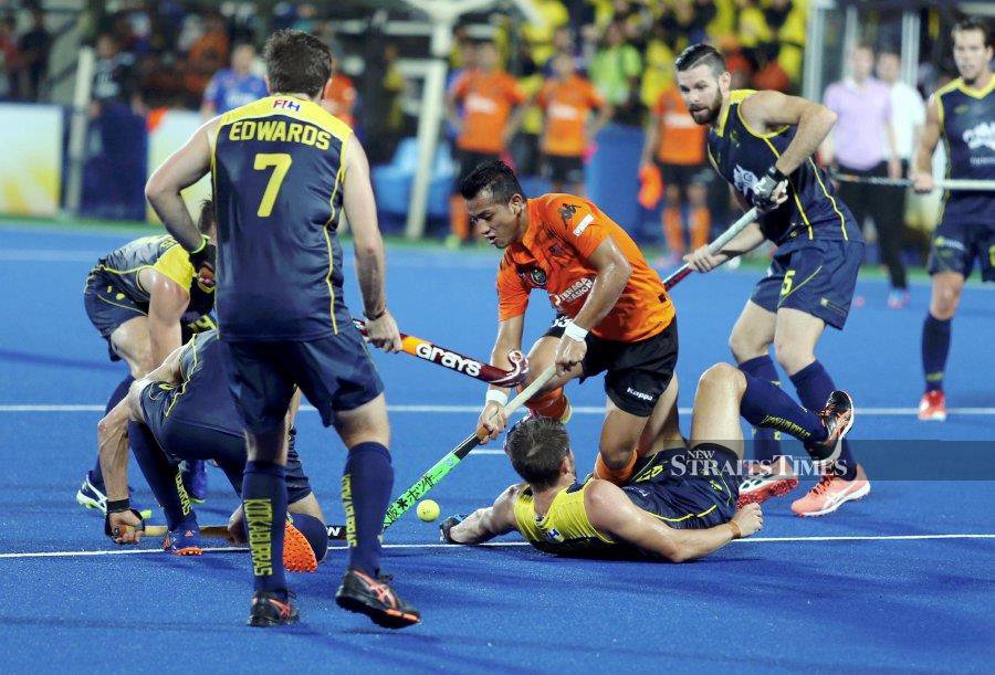 Forward Firhan Ashaari (Orange) is approaching the twilight of his hockey career, and he hopes to earn an Olympic pin before he retires. NSTP FILE PIC