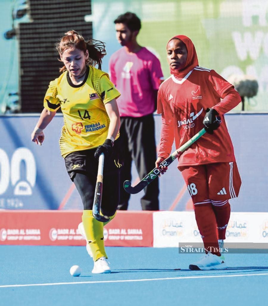 A Malaysia player (left) tussling for the ball with an Oman player at the Hockey 5s World Cup in Muscat, Oman, yesterday. 