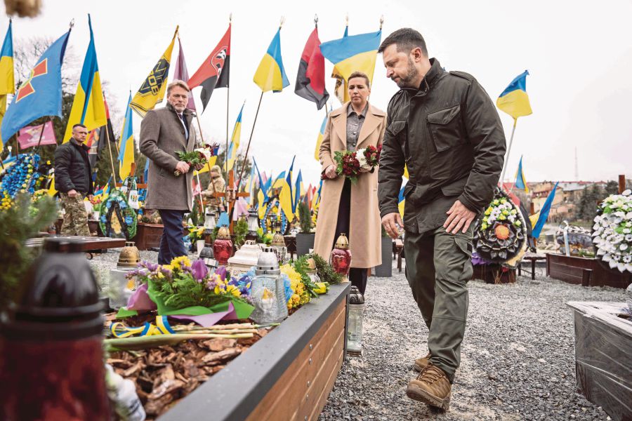  Ukrainian President Volodymyr Zelensky (right) and Danish Prime Minister Mette Frederiksen (centre) laying flowers during a memorial ceremony in Lviv, Ukraine, on Friday, on the eve of the second anniversary of Russia’s invasion of Ukraine. AFP PIC 