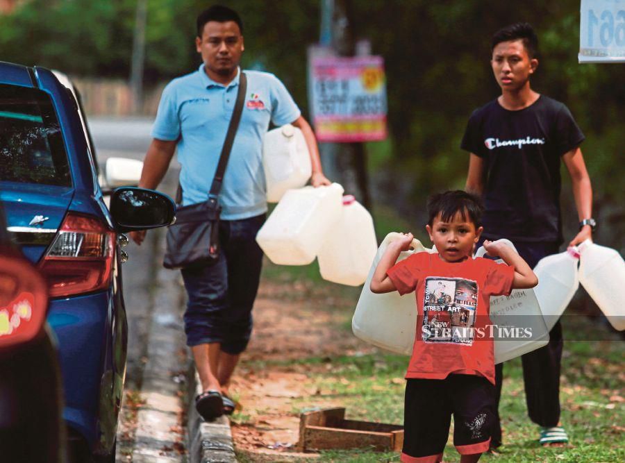 People carrying containers to fill water from public pipes in Seksyen 16 in Shah Alam yesterday. PIC BY SAIRIEN NAFIS
