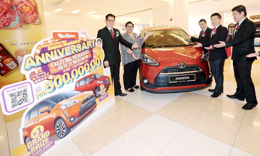 The Store Group’s ambassador Adibah Noor (2nd from left) with the group’s executive director William Tang Chee Weng (2nd from right) show the grand prize — a Toyota Sienta. Pic by L. MANIMARAN