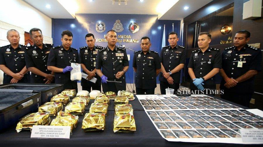 Deputy Penang police chief Datuk Mohamed Usof Jan Mohamad (centre) showing some of the syabu hidden in Chinese tea packaging seized at a house in Nibong Tebal, George Town, yesterday. NSTP/MIKAIL ONG