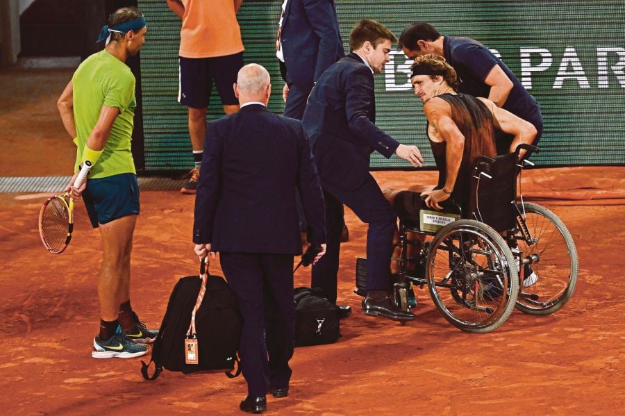 Germany's Alexander Zverev (R) is assisted next to Spain's Rafael Nadal as he leaves the court in a wheelchair after being injured during his men's semi-final singles match against Spain's Rafael Nadal on day thirteen of the Roland-Garros Open tennis tournament at the Court Philippe-Chatrier in Paris on June 3, 2022. AFP FILE PIC