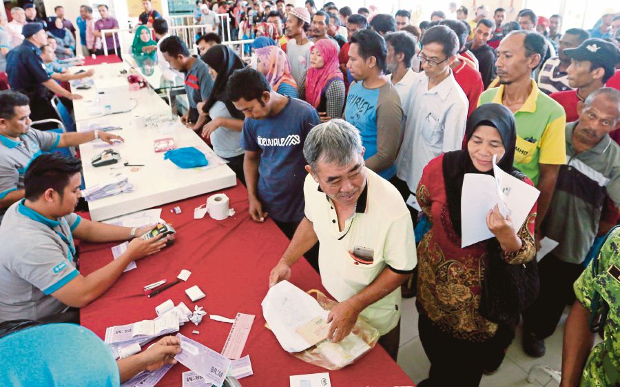 People queueing to receive their 1Malaysia People’s Aid (BR1M) vouchers. The programme has helped to address the rise in the cost of living. FILE PIC 