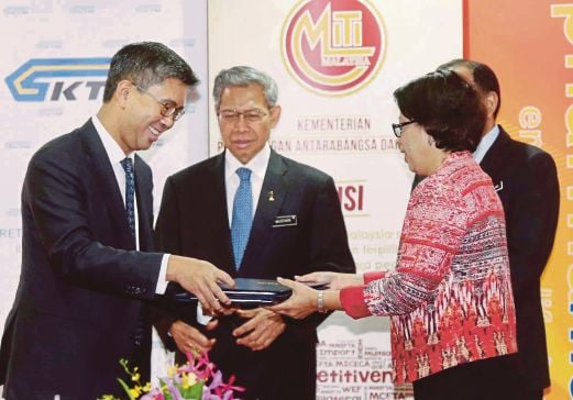 International Trade and Industry Minister Datuk Seri Mustapa Mohamed witnessing the exchange of documents between ministry secretary-general Datuk Dr Rebecca Fatima Sta Maria (right) and CIMB Group chief executive officer Tengku Datuk Zafrul Tengku Abdul Aziz at the signing of the vendor development programme yesterday. Pic by Mohd Yusni Ariffin