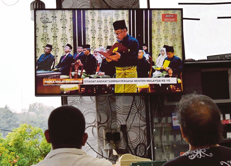 People in Kota Kinabalu watching the live telecast of the swearing-in of Datuk Seri Anwar Ibrahim as the 10th prime minister at Istana Negara  on Thursday.  PIC BY ADAM ARININ