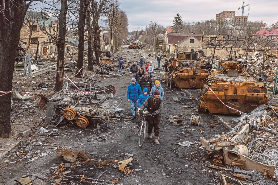  Residents walk past destroyed Russian military machinery on the street, in Bucha, the town which was retaken by the Ukrainian army, northwest of Kyiv, Ukraine. - EPA Pic
