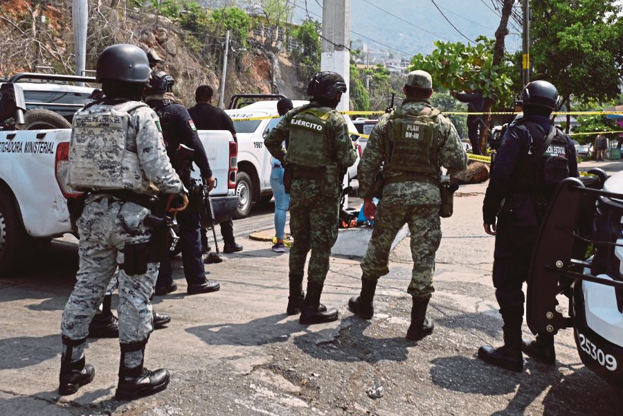  Security forces standing guard at the site where the PRI candidate for mayor of Coyuca de Benitez, Anibal Zuniga Cortes, and his wife, Ruby Bravo, were killed in Acapulco, Mexico, on May 16. AFP PIC 