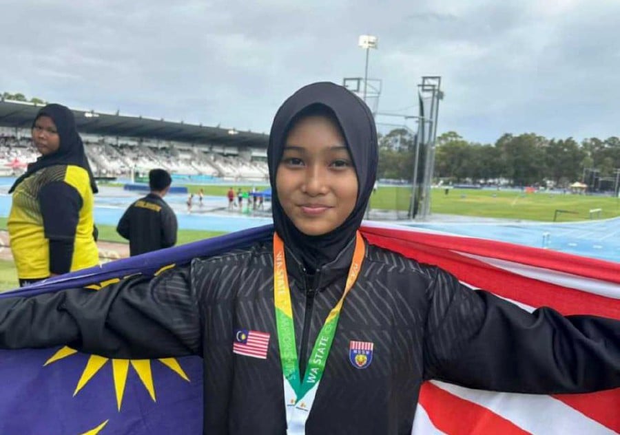 Sabah’s Nurelfira Umaira Yusuf celebrates after winning the girls’ Under-14 80m hurdles gold medal at the Western Australia State Track & Field Championships in Perth last weekend. PIC COURTESY OF KARIM BATJO
