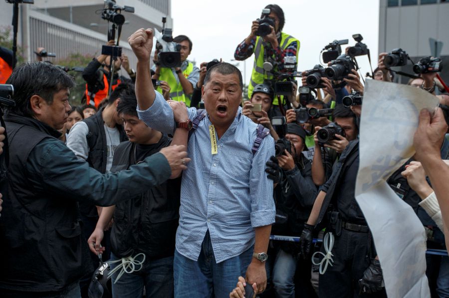 Tycoon and Apple Daily Newspaper owner Jimmy Lai shouts slogan before he is taken away by police officer at an area previously blocked by pro-democracy supporters, outside the government headquarters in Hong Kong, December 11, 2014. - REUTERS PIC