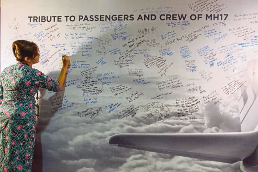 A Malaysian Airlines crew member writes a message of condolence after multi-faith prayers for passengers and crew of crashed Malaysia Airlines flight MH17 at the Malaysia Airlines Academy in Kelana Jaya, Malaysia, 25 July 2014. A Malaysia Airlines Boeing 777 with more than 280 passengers, crashed in eastern Ukraine on 17 July. The plane went down between the city of Donetsk and the Russian border, an area that has seen heavy fighting between separatists and Ukrainian government forces. EPA