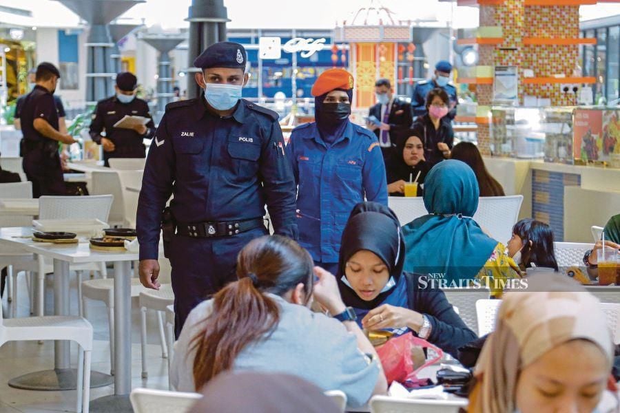 Police  conducting a check on standard operating procedure compliance at a shopping complex in Kuala Lumpur last month. - NSTP/AIZUDDIN SAAD