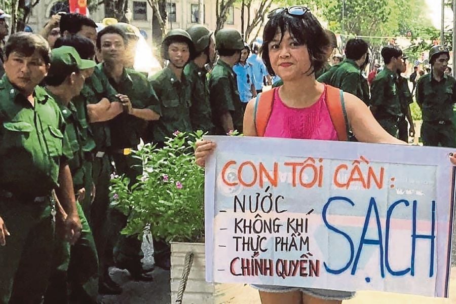 A handout photo released on Oct 24 by Hoang Vinh Nam shows his wife, Hoang Thi Minh Hong, holding a banner during a protest in Ho Chi Minh in 2017. AFP PIC/HOANG VINH NAM