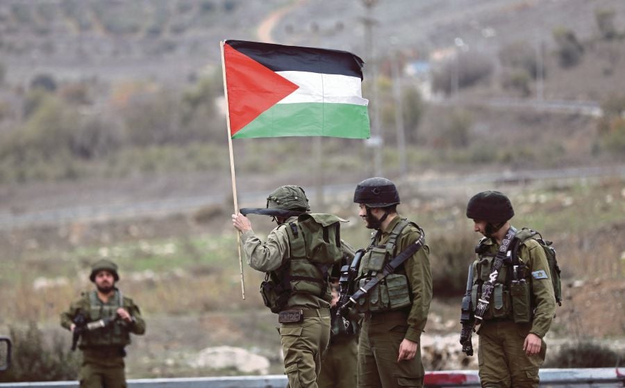 Israeli soldiers remove a Palestinian flag during clashes at the Huwwara checkpoint, near Nablus, recently. Lask week, the United Nations General Assembly called on the United States to withdraw its recognition of Jerusalem as the capital of Israel. The resolution was approved by 128 states, with 35 abstaining and nine others voting against it. EPA PIC 
