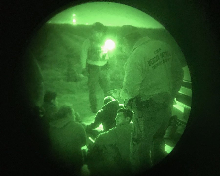 (File pix) As seen through night vision goggles, a US Border Patrol agent stands guard over a group of undocumented immigrants on Feb 23, 2018 in McAllen, Texas. The border agents had captured the group after they crossed illegally from Mexico into the United States. AFP Photo