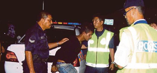 Policemen with a suspect apprehended by the public in Sungai Petani yesterday. Pic by Omar Osman