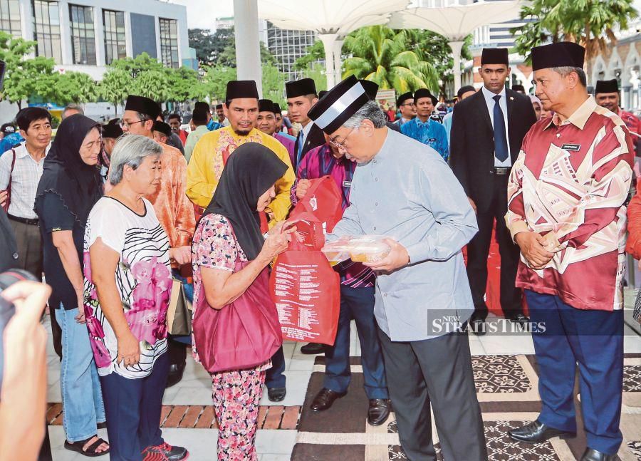  Yang di-Pertuan Agong Al-Sultan Abdullah Ri’ayatuddin Al-Mustafa Billah Shah presenting aid to the needy in Kuala Lumpur recently. His Majesty wants to enhance what is common among Malaysians and not let differences separate the people. PIC BY ASWADI ALIAS