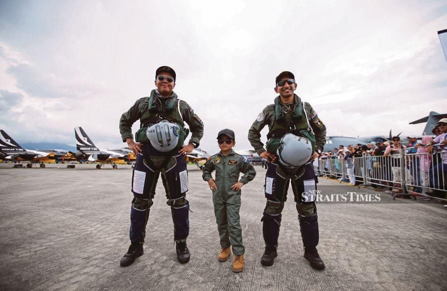 Lieutenant-Colonel Mohd Norazan Othman ((left) and fellow pilot Major Muhammad Osman Mohd Sidek posing with Sharifah Elayna Syed Fadley at the Langkawi International Airport’s tarmac on Friday. PIC BY ASWADI ALIAS.