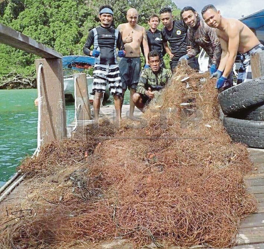  Divers with another ghost net found at the same dive site. PIC BY JUDE JUNIUS
